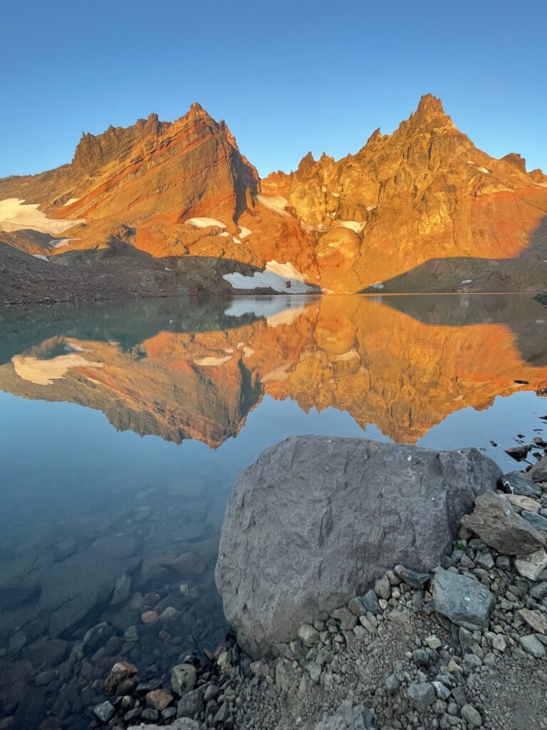 Sunrise lights up the cliffs of Broken Top at No Name Lake