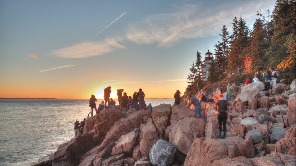 Photographers crowd the rocks positioning for a sunset shot of Bass Harbor Head Light House, Acadia, National Park.