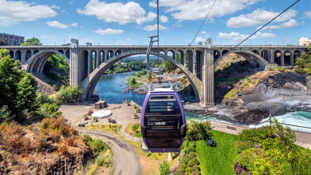Sky Ride gondolas on cables above the Spokane Falls and River in downtown Riverfront Park, Spokane, Washington during summer.