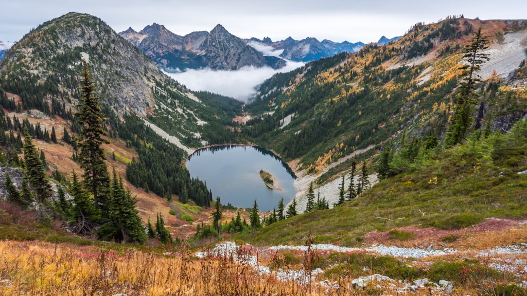 A small lake amidst the scenic autumn mountains shrouded in mist, HEATHER-MAPLE PASS LOOP TRAIL, Washington state