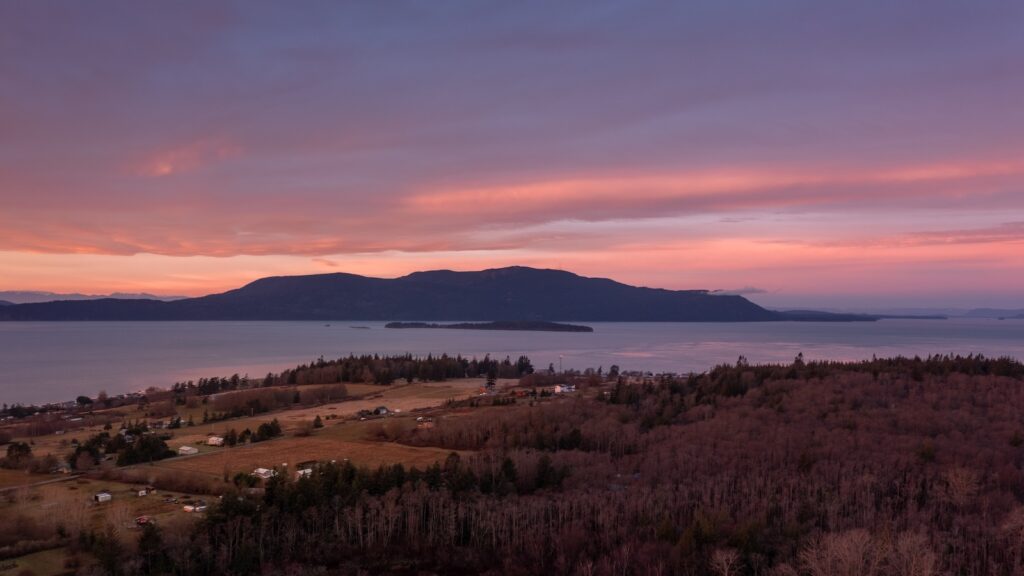 Aerial View of Sunrise Over Orcas Island, Washington. Located in the Salish Sea, Orcas Island is seen from Lummi Island across the Rosario Strait in the San Juan Island archipelago.