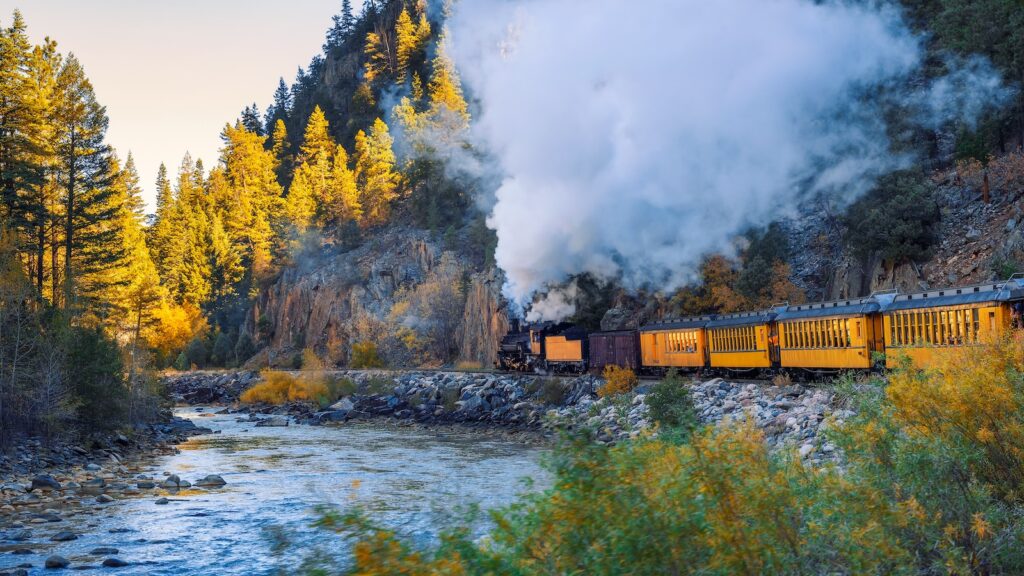 Historic steam engine train travels from Durango to Silverton through the San Juan Mountains along the Animas River in Colorado