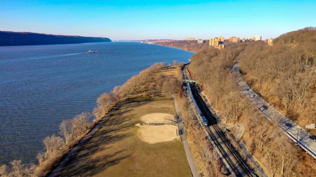 Henry Hudson Parkway and Amtrak train on railroad along the western northern tip of Manhattan, New York City.