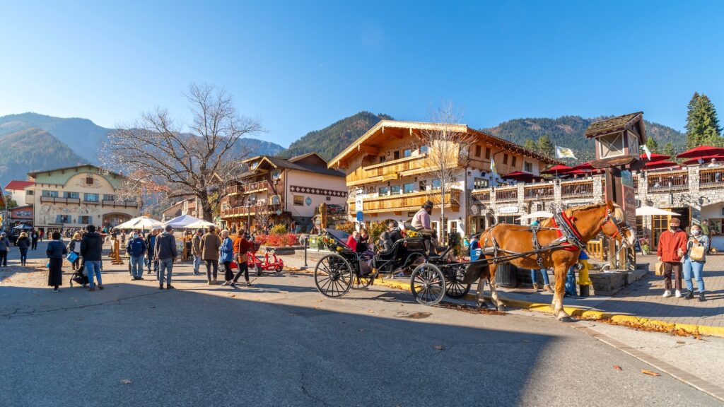 A horse carriage for hire with tourists in the colorful Bavarian themed village of Leavenworth.