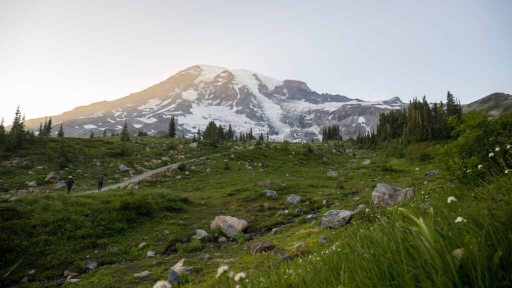 Mount Rainier at sunset. People hiking Paradise valley. Mt Rainier National Park. Washington State. USA.